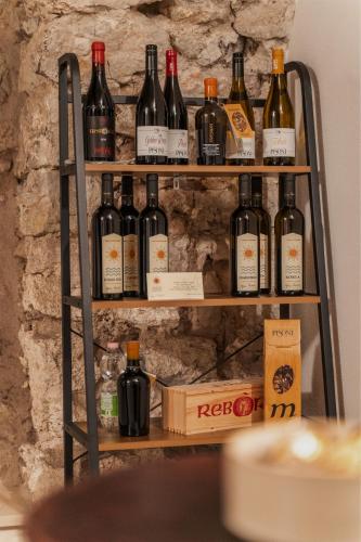 a shelf full of wine bottles on a wall at Pietra Rara Apartments in Pietramurata