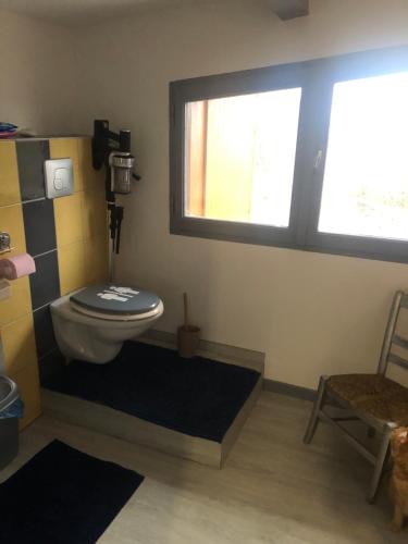 La salle de bains est pourvue de toilettes et d'une fenêtre. dans l'établissement Chambre chez l'habitant, à Châteauvieux