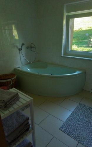 a bath tub in a bathroom with a window at 4 Personen Ferienwohnung in Hohnstein