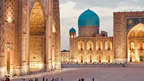 a mosque with a blue dome and people standing in front of it at Samarkand Central Apartments in Samarkand
