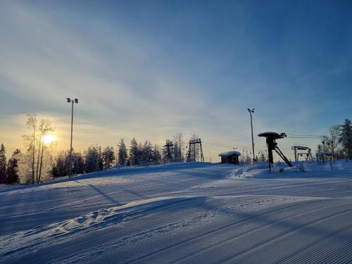 ユヴァスキュラにあるOutdoor Hostel Laajisの遠くにスキーリフト付きの雪に覆われた坂道