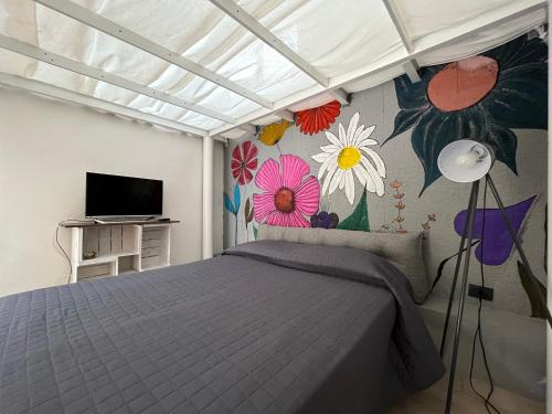 a bedroom with a bed and flowers painted on the wall at U Pantanu in Syracuse
