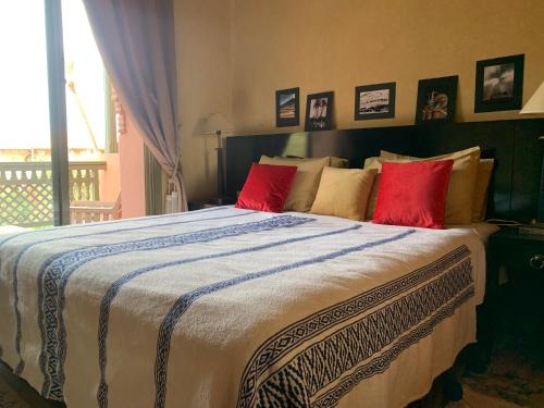 um quarto com uma cama grande e almofadas vermelhas em AbirKech appartement em Marrakech