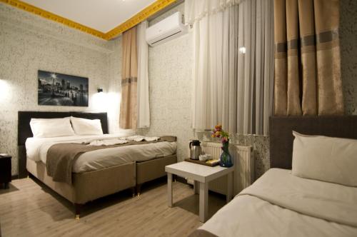 a hotel room with two beds and a table at Golden Horn Park Hotel in Istanbul