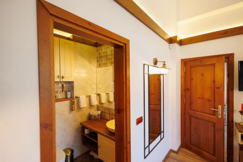 a bathroom with a wooden door and a sink at Mountain villa Jordan- with JACUZZI in Razlog