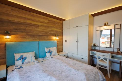 a bedroom with a blue bed and a desk at Mountain villa Jordan- with JACUZZI in Razlog