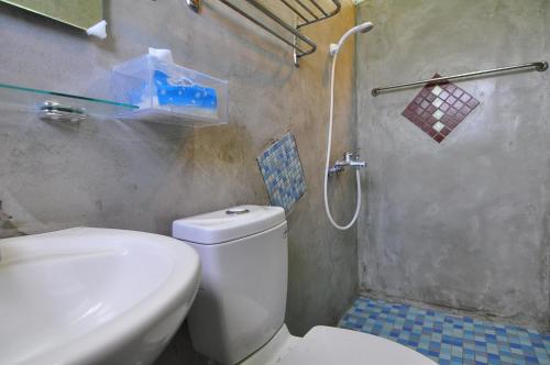 a bathroom with a white toilet and a shower at Tap Bed & Breakfast in Taitung City