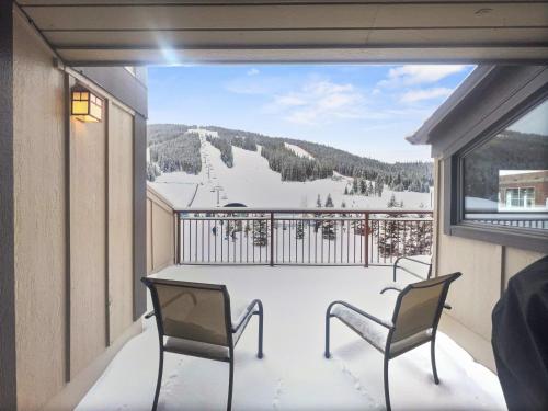 un balcón con 2 sillas y vistas a una pista de esquí. en VP211 Village Point condo en Copper Mountain