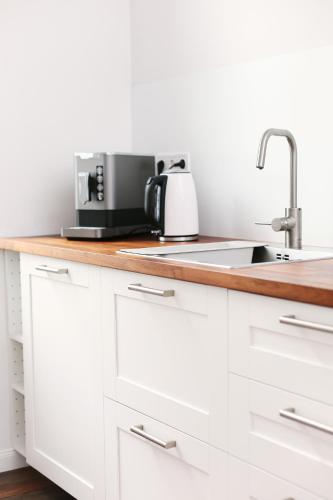 a kitchen with white cabinets and a sink at Villa Alexandra 1897 Wohnung Maria in Bad Wildungen