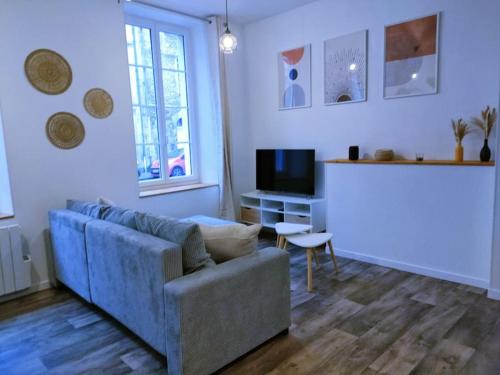 a living room with a couch and a tv at Logement proche Hypercentre CAEN in Caen