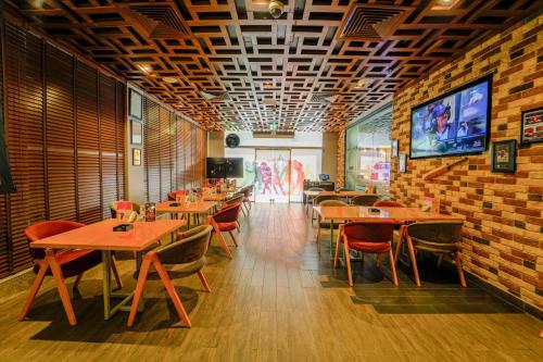 a restaurant with wooden tables and chairs and a tv at Mercure Dubai Barsha Heights Hotel Suites And Apartments in Dubai