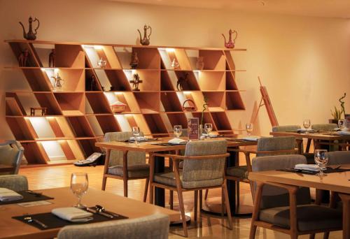 a restaurant with wooden tables and chairs and shelves at Mercure Dubai Barsha Heights Hotel Suites And Apartments in Dubai