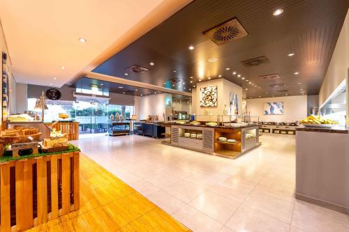 a restaurant with a large kitchen and a cafeteria at Mercure Dubai Barsha Heights Hotel Suites And Apartments in Dubai