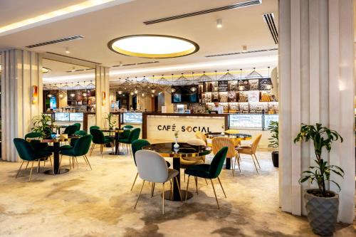 a restaurant with tables and chairs and a signone social at Mercure Dubai Barsha Heights Hotel Suites And Apartments in Dubai