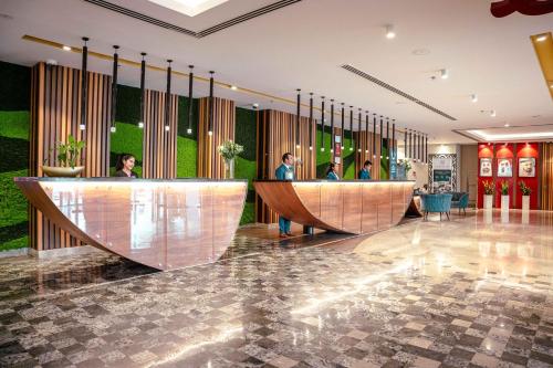 a lobby with people waiting at the reception desks at Mercure Dubai Barsha Heights Hotel Suites And Apartments in Dubai
