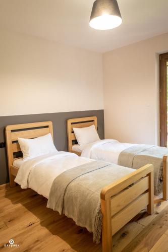 two beds sitting next to each other in a room at Zarębisko - noclegi całoroczne in Zwierzyniec
