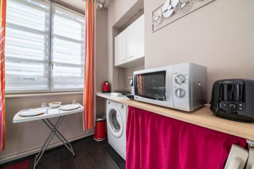 une cuisine avec un micro-ondes et un lave-linge dans l'établissement Charmant studio Hyper-centre, à Lyon