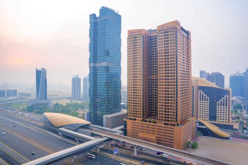 a city with tall buildings and a highway with cars at Mercure Dubai Barsha Heights Hotel Suites And Apartments in Dubai