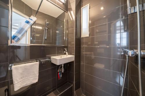 une salle de bain avec un lavabo et un miroir dans l'établissement Charmant studio Hyper-centre, à Lyon