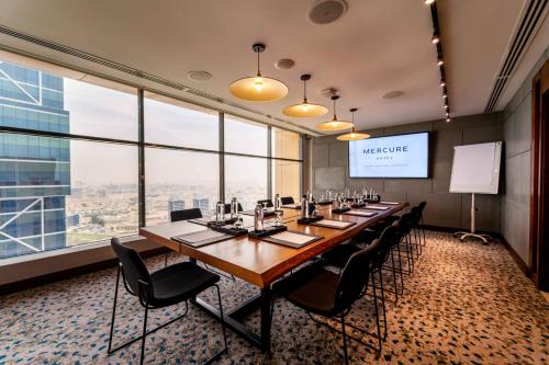 a conference room with a long table and chairs at Mercure Dubai Barsha Heights Hotel Suites And Apartments in Dubai