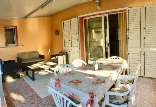 a room with a table and chairs and a patio at Holiday House Monte Longu in Posada