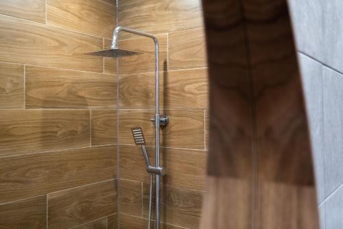 eine Dusche mit einer Holzwand und einem Duschkopf in der Unterkunft Stylish Gem 2BR Apartment with AC in Sofia
