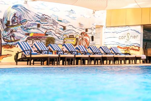 a group of chairs in front of a wall with a mural at Mercure Dubai Barsha Heights Hotel Suites And Apartments in Dubai