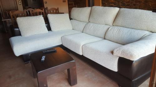a living room with a white couch and a table at Casa la Felguerina in La Felguerina