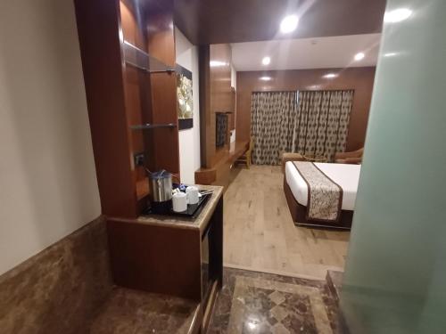 a hotel room with a bed and a bathroom at Hotel Benzz Park Chennai in Chennai