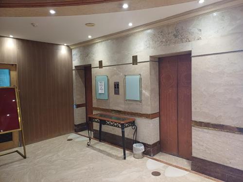 a room with a table and a mirror on a wall at Hotel Benzz Park Chennai in Chennai