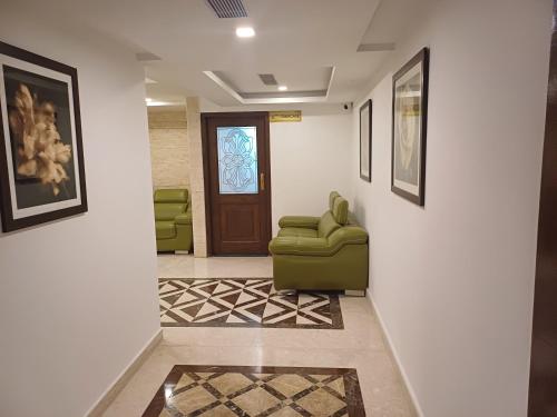 a hallway with a green chair and a door at Hotel Benzz Park Chennai in Chennai