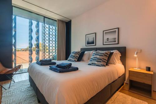 a bedroom with a bed with two towels on it at New Luxury Central Cascais in Cascais