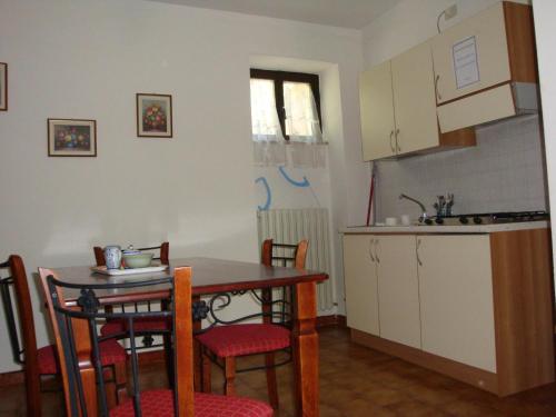 a kitchen with a table and chairs and a kitchen with a sink at Affitta camere Il Ruscello in Scheggino