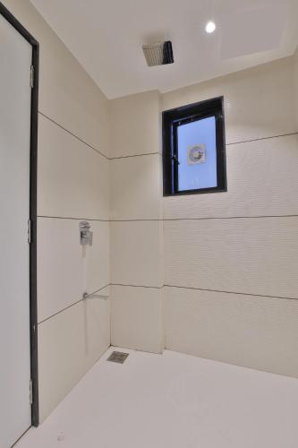 a shower with a glass door in a room at Hotel Elements Surat in Surat
