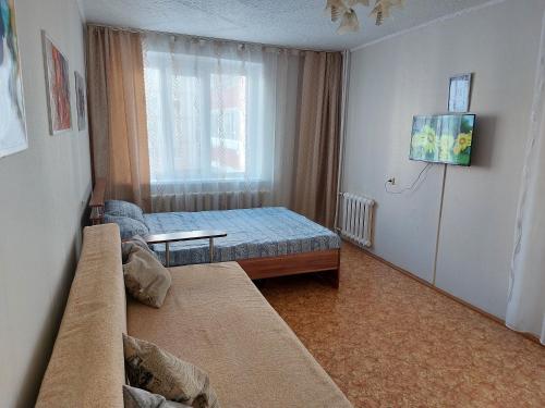 ein kleines Schlafzimmer mit einem Bett und einem Fenster in der Unterkunft Уютная квартира с удобным расположением in Līsakovsk
