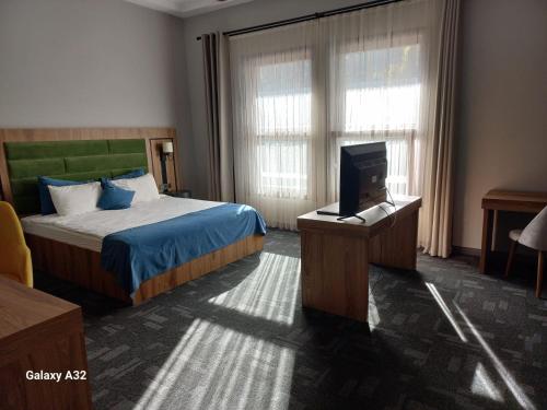 a hotel room with a bed and a tv at ERTA SOYAK THERMAL OTEL in Çekirge