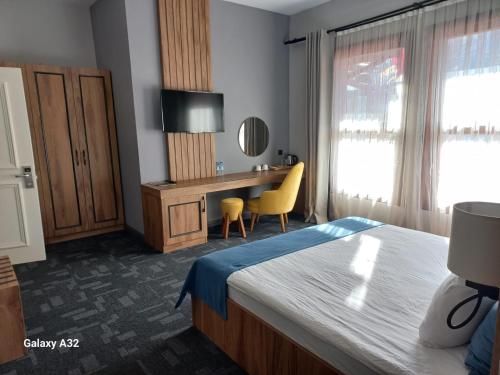 a bedroom with a bed and a desk with a chair at ERTA SOYAK THERMAL OTEL in Çekirge