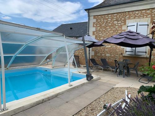 einen Pool mit Glaserweiterung zu einem Haus in der Unterkunft La Costonnerie in Leigné-sur-Usseau