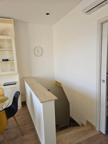 a room with a desk and a clock on the wall at Sunny House Apartment 44 Malta in Taʼ Xbiex
