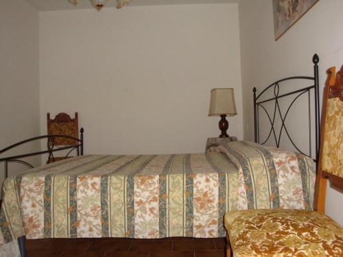 a bedroom with a bed and a lamp and a chair at Affitta camere Il Ruscello in Scheggino