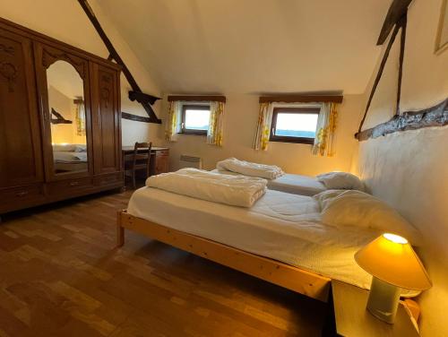 um quarto com 2 camas, uma cómoda e um espelho em Sommette em Somme-Leuze