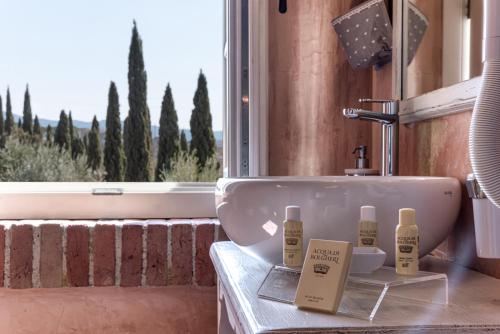 baño con lavabo y ventana con árboles en Locanda dell'Aioncino en Bibbona