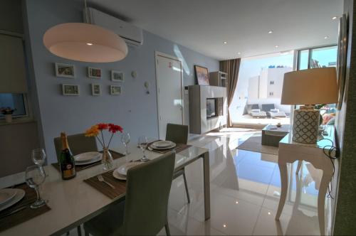 una sala da pranzo con tavolo e sedie e una stanza con vista di Penthouse Deluxe a Sliema