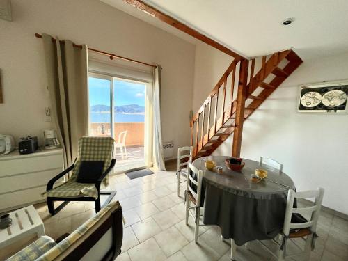 une salle à manger avec une table et des chaises et une fenêtre dans l'établissement Duplex Hameaux du soleil PORTICCIO, à Porticcio