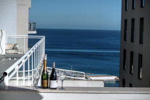 due bottiglie di vino e bicchieri su un balcone con vista sull'oceano di Penthouse Deluxe a Sliema