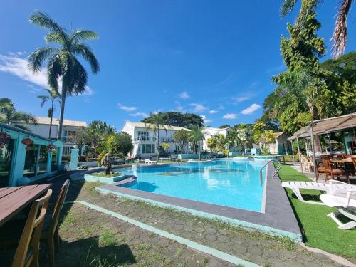 a swimming pool in a resort with chairs and tables at Asian Greenville Hotel and Resort in Clark