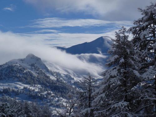 a view of a snowy mountain valley with trees at le Chal'heureux in Vars