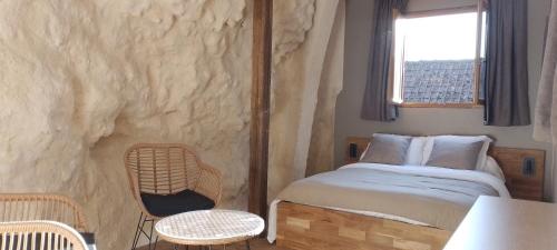a bedroom with a bed in a stone wall at Ô 87 - chambres d'hôtes in Amboise