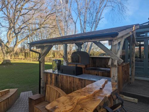 a wooden deck with a wooden table and a grill at The Agents House, Bed & Breakfast in Hereford