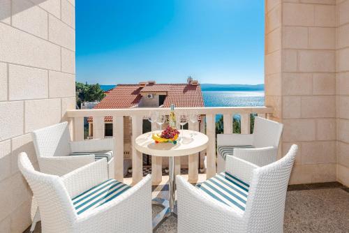 a patio with chairs and a table with a cake on it at Hotel Villa MiraMar in Omiš